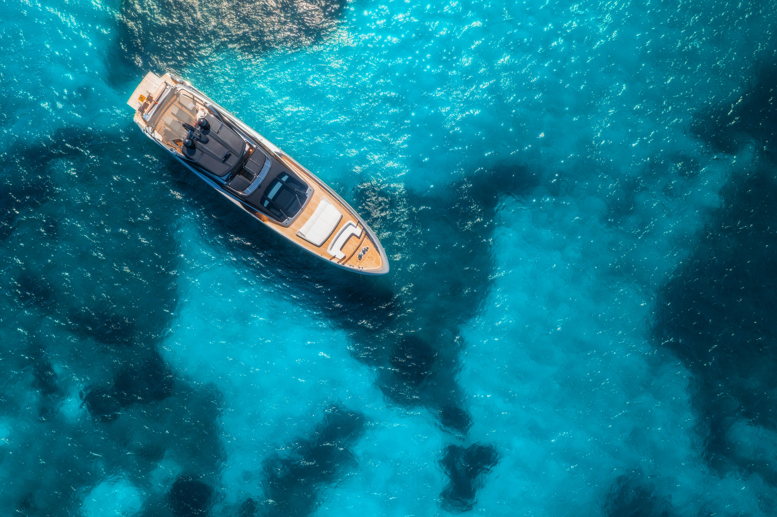 Aerial view of luxury yacht on blue sea at sunset in summer